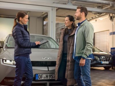 3 personnes en train de discuter devant IONIQ 5