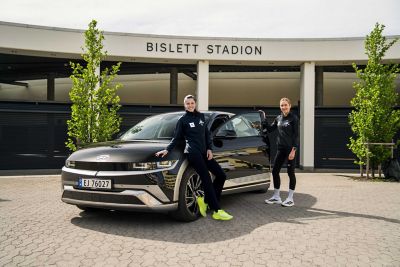 Amalie Iuel og Karoline Bjerkeli Grøvdal ved siden av en IONIQ 5. Foto.