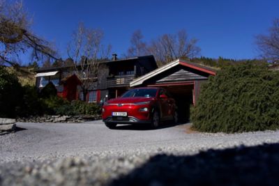 KONA Electric parkert ved en garasje. Foto.