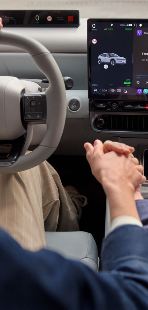 Close up of two people holding hands in front of the center touch screen of the Hyundai IONIQ 3.