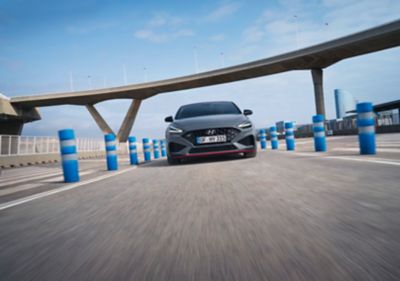 The new Hyundai i30 Fastback N in Performance Blue driving on a racetrack.