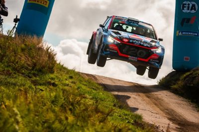 Hyundai i20 N Rally2 jumping through a timing gate during a race