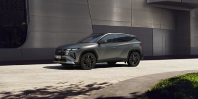 Nový Hyundai TUCSON stojící v moderní ulici.