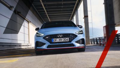 Hyundai i30 N spredu jazdiaci po mestskej ulici.