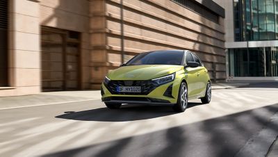 Nový Hyundai i20 v žltej farbe v mestskom prostredí.