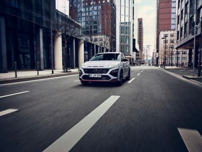 Hyundai KONA N hot SUV driving through an empty cityscape.