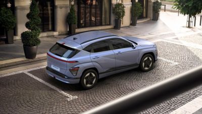 The Hyundai KONA Electric in blue parked on a road. 