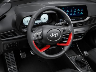 Steering wheel inlays and door handle trims in the cockpit of the Hyundai BAYON in aqua turquoise.