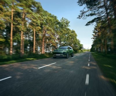 Hyundai IONIQ 9 electric SUV driving on a tree-lined road