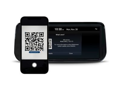 Hyundai display and a smartphone showing the update screen of the Infotainment update portal.