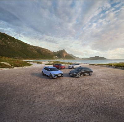 Rangebilde av KONA Electric, IONIQ 5, IONIQ 6 og IONIQ 5 N parkert i naturlandskap. Foto.