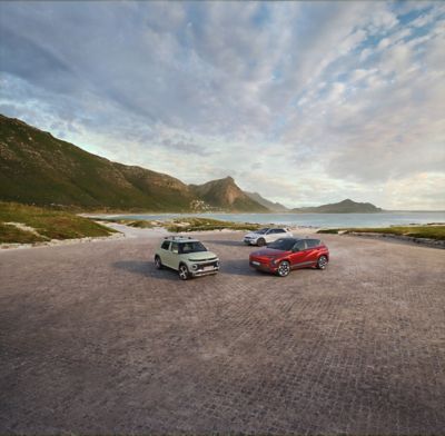Rangebilde av KONA Electric, IONIQ 5, og INSTER parkert i naturlandskap. Foto.