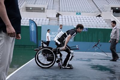 Paralympic athlete Jun-beom Park standing up from his whellchair with Hyundai robotic legs