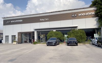 Vista esterna Showroom Roby Cars con due KONA parcheggiate davanti, una grigia e l'altra nera