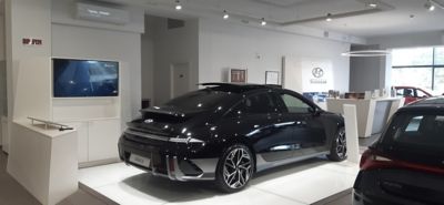 Vista posteriore di tre quarti di IONIQ 6 Nera all'interno dello showroom