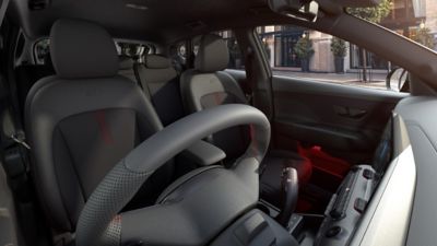 The sporty front seats of the KONA Electric N Line with red accents and ambient lighting.