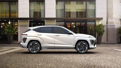 The all-new KONA N Line in white parked next to a modern building.