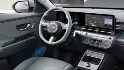 Das vordere Interieur eines Hyundai KONA mit Lenkrad, Displays und Bedienelementen.