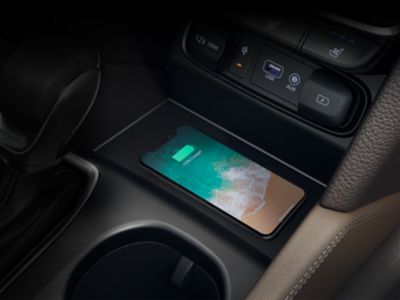 Smartphone Qi placé dans le socle de charge sans fil, dans la console centrale d’une Hyundai.