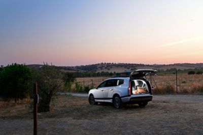 Bagasjerom dekket for camping og bilen er pyntet med lys. Foto.