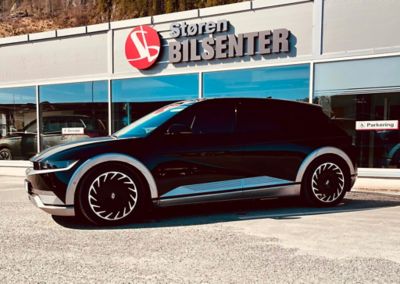 En IONIQ 5 står parkert utenfor lokalene til Støren Bilsenter. Foto.