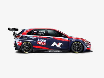  A picture of Hyundai Motorsport customer racing i30 N TCR in action on a racetrack shown from the side.	
