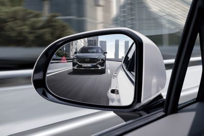 The side mirror of the Hyundai Santa Fe Hybrid 7 seat SUV reflecting another Santa Fe hybrid.
