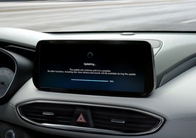 Un écran tactile central à l’intérieur d’un véhicule Hyundai avec l’écran affichant une mise à jour logicielle.