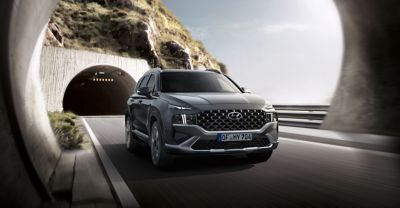 Nowy 7-miejscowy SUV Hyundai SANTA FE Hybrid jadący przez tunel.