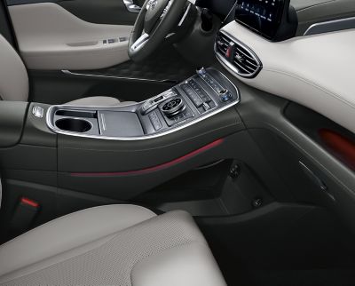 Półka pod uniesioną konsolą środkową nowego 7-miejscowego SUV-a Hyundai SANTA FE Plug-in Hybrid.