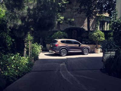 Imagen del nuevo Hyundai SANTA FE Híbrido Enchufable aparcado en la calle de una ciudad.