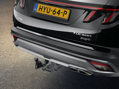 A woman looking at her bicycle, which is fixed to the KONA Electric bike carrier for tow bars.