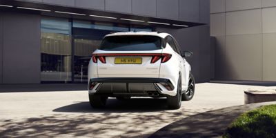A woman walking behind the Hyundai TUCSON Plug-in Hybrid. 