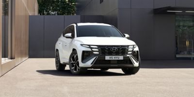 The Hyundai TUCSON Plug-in Hybrid parked in front of a building. 