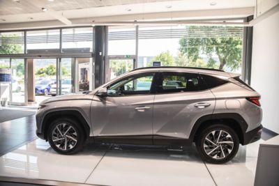 Hyundai TUCON grigio chiaro visto di lato dentro allo showroom