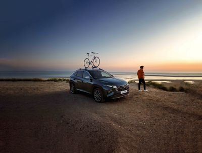 The Hyundai TUCSON with accessories in the sunset at a beach.