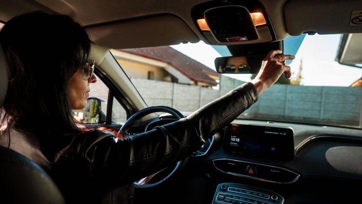 žena nastavujúca si vnútorné spätné zrkadlo vo svojom Santa Fe Hybrid