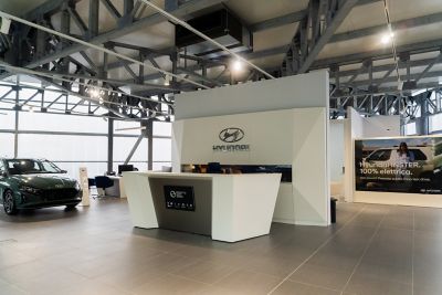 Donna carica un modello Hyundai aiutata da un'assistente Hyundai