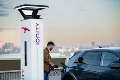 Man plugging in IONITY charger to his Hyundai.