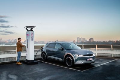 The Hyundai IONIQ 5 electric vehicle charging at an IONITY charging station on a rooftop.