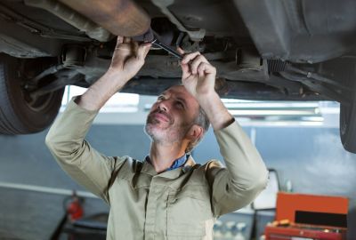 Mężczyzna serwisujący podwozie samochodu Hyundai.