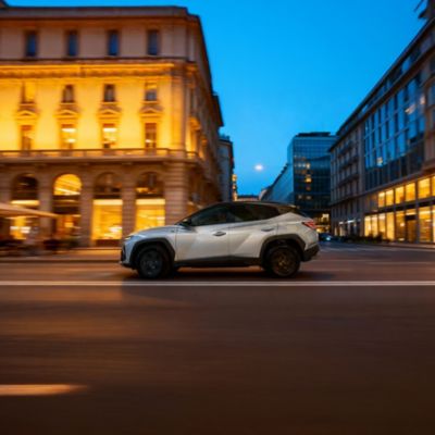 The Hyundai TUCSON Plug-in Hybrid parked next to a building.