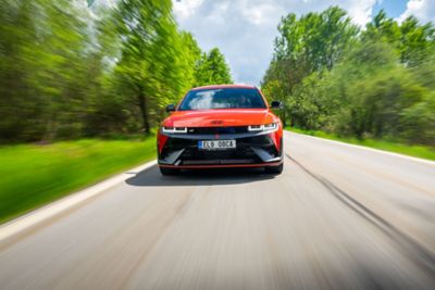 Model IONIQ 5 jedoucí po okresní silnici.