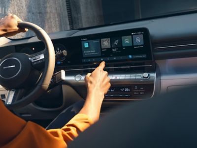 A person using the centre touchscreen inside the Hyundai KONA.