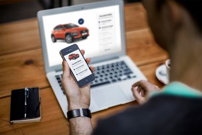 Kobieta i mężczyzna idą obok zaparkowanego samochodu Hyundai SANTA FE.