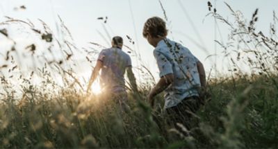 niño pasea junto an adulto por el campo