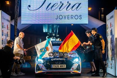 Hyundai de rally en la ceremonia de salida del Rallye de Ourense con banderas de Galicia y España
