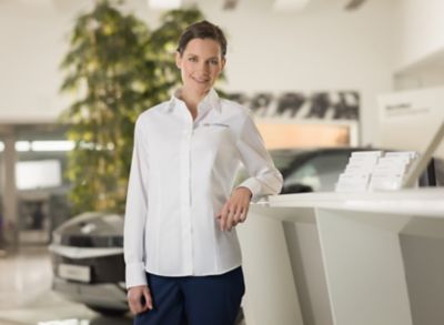 Une femme en chemise Hyundai dans une concession