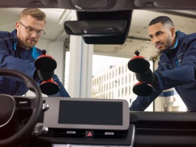 Twee mannen met zuignap op autoraam