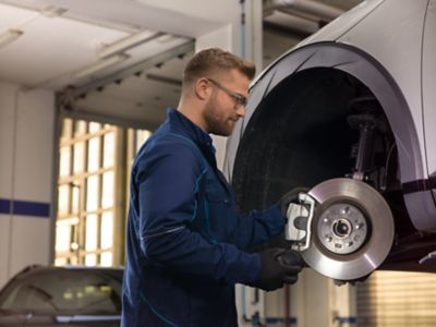 Hyundai mechanic checks the brakes of the Hyundai.